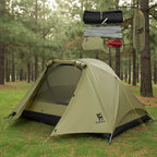 Green camping tent with accessories on a forest background - offered by the best camping gear store in Massachusetts, The Adirondack Tool Co.
