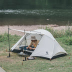 Person camping by a river with a Qunature 2-person tent - offered by the best camping gear store in Massachusetts, The Adirondack Tool Co.