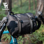 Black bike bag with Qunature branding attached to a bicycle handlebar in a forest setting - offered by the best biking gear store in New York, The Adirondack Tool Co.