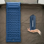 Blue inflatable sleeping pad with a hand holding its folded version on a tent background - offered by the best outdoor gear store and hiking guide service in New York, The Adirondack Tool Co.