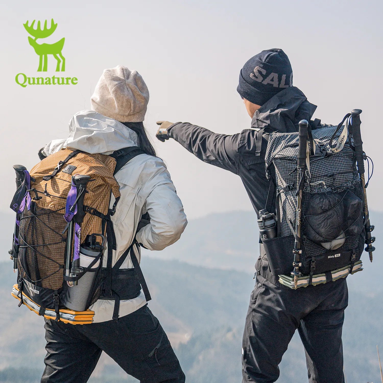 Two hikers with backpacks pointing towards a mountain peak, Qunature logo visible.
