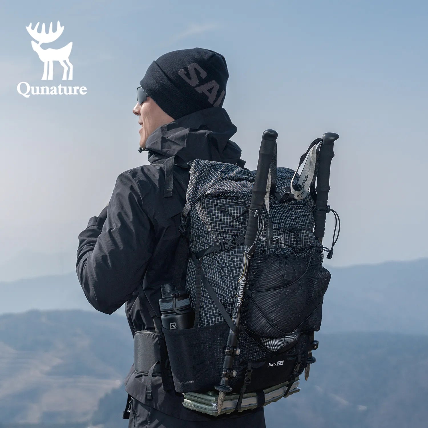 Person wearing a black backpack with a scenic background, featuring the Qunature brand logo.