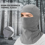 Person wearing a gray balaclava in a snowy forest with text 'Seamless Sewing & Thermal Fleece' - offered by the best hiking gear store in the United States, The Adirondack Tool Co.